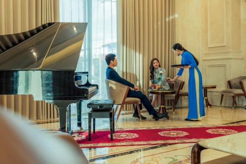 a man and a woman standing in front of a piano at THE SHINE HOTEL in Hai Phong