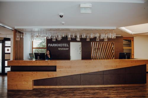 a woman standing at a reception desk in a lobby at Parkhotel Brunauer in Salzburg