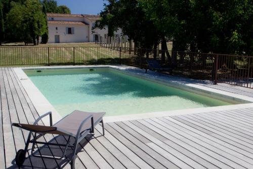 eine Terrasse mit einem Stuhl und einem Pool in der Unterkunft Château La Croix Des Pins in Mazan