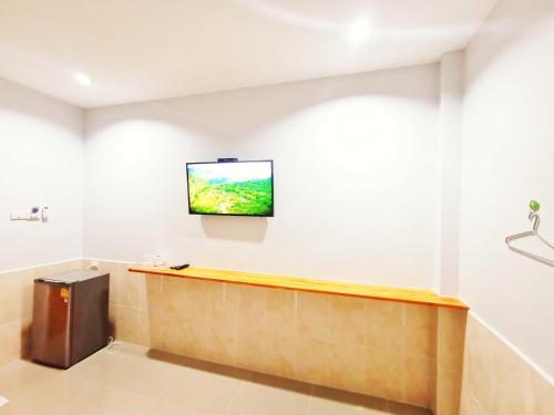 a flat screen tv on a wall in a room at ลิตเติ้ล ฮิลล์ สัตหีบ รีสอร์ท ( Little Hill Sattahip Resort ) in Sattahip