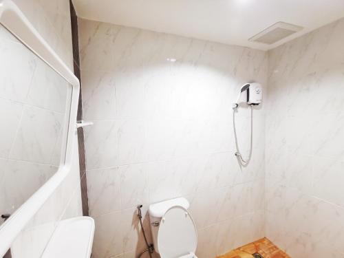 a white bathroom with a toilet and a shower at ลิตเติ้ล ฮิลล์ สัตหีบ รีสอร์ท ( Little Hill Sattahip Resort ) in Sattahip