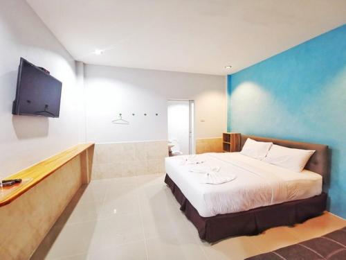 a bedroom with a bed and a flat screen tv at ลิตเติ้ล ฮิลล์ สัตหีบ รีสอร์ท ( Little Hill Sattahip Resort ) in Sattahip