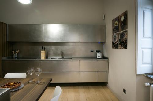 una cocina con una mesa con copas de vino. en Mameli Suite en Casale Monferrato