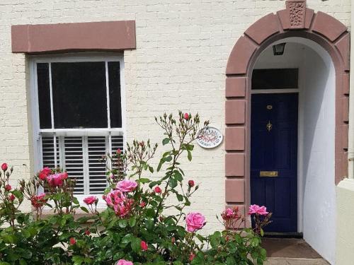 a house with a blue door and a window at Cherry End Bed and Breakfast in Chichester