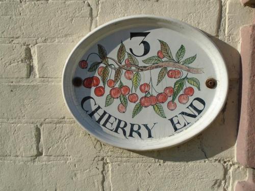 a clock on a brick wall with the words cherry lane at Cherry End Bed and Breakfast in Chichester