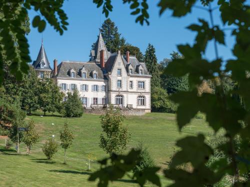 une vieille maison sur un champ herbeux avec des arbres dans l'établissement Château de Saint-Antoine, à Bonnac-la-Côte