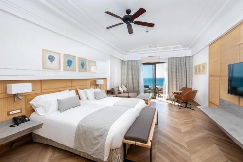 a hotel room with a large bed and a television at Hotel Riu Palace Tikida Taghazout - All Inclusive in Taghazout