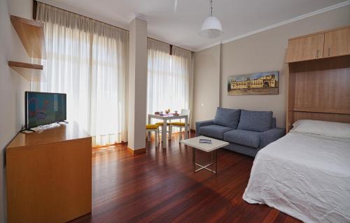 a living room filled with furniture and a tv at Hotel Apartamentos Dabarca in Pontevedra