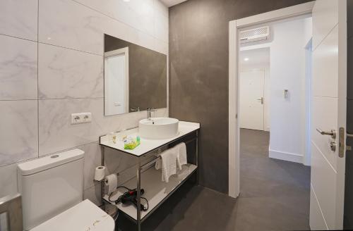ポンテベドラにあるHotel Apartamentos Dabarcaの白いバスルーム(洗面台、トイレ付)