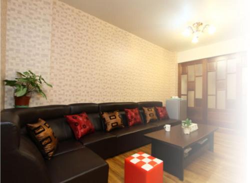 a living room with a black couch and a table at Chyi's House in Luodong