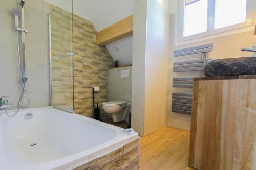 y baño con bañera y aseo. en L'étang de la Tourne, en Les Marches