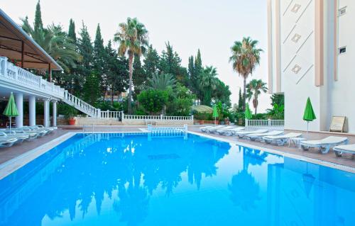 阿夫薩拉爾的住宿－Ramira Beach Hotel - All Inclusive，一座带躺椅的游泳池和一座建筑