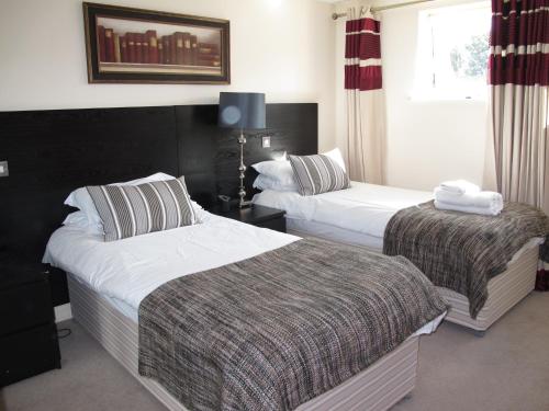 a hotel room with two beds and a window at Churchill Two Bedroom Apartments with Free Parking and The Minster view in York