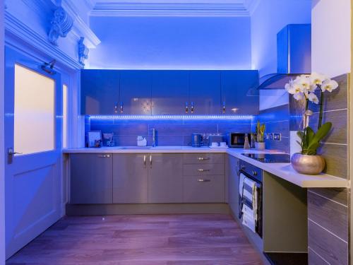 a blue kitchen with blue cabinets and a counter at Church Lane Apartments in Boston