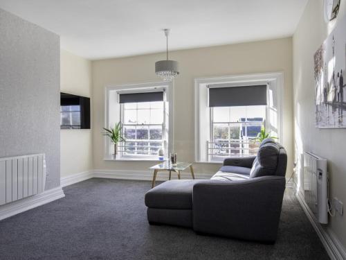 a living room with a couch and two windows at Church Lane Apartments in Boston