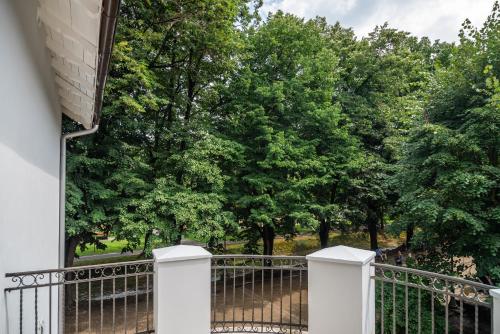 a white fence with trees in the background at Vila Emilia in Vrnjačka Banja
