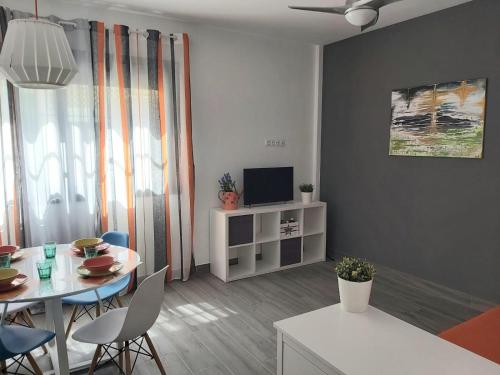 a living room with a table and a tv at Bnbook Medea Apartments in Fuengirola
