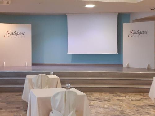 a room with two tables and a white screen at Hotel Saligari in Verceia