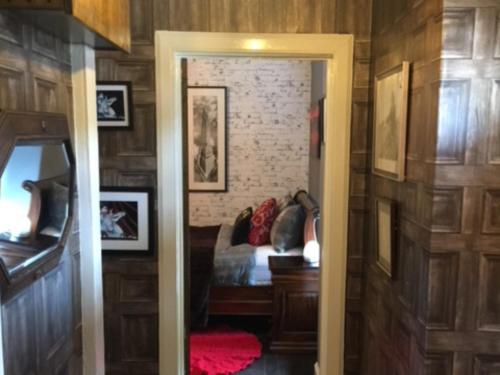 a bedroom with a bed in a room with wooden walls at The Clacks Rustic Abode in Tillicoultry