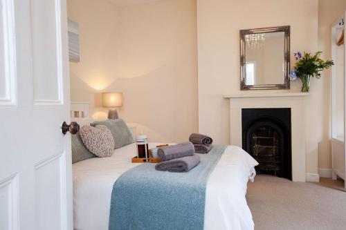 - une chambre avec un lit, une cheminée et un miroir dans l'établissement Clarence Cottage, à Whitby
