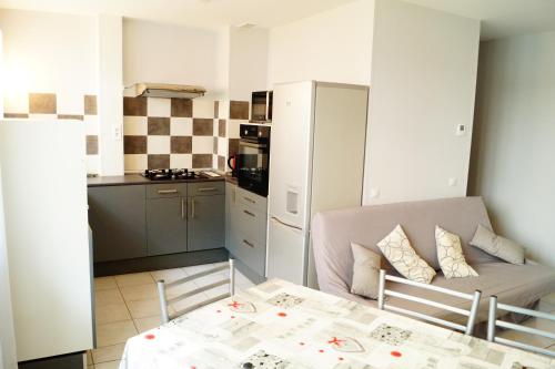 - une cuisine avec une table et un canapé dans une chambre dans l'établissement Gite One Luchon appartement 6 personnes, à Luchon