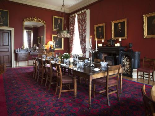 a dining room with a long table and chairs at Clonalis House - Guesthouse in Castlerea