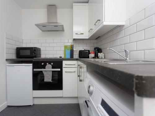 a kitchen with a stove and a sink in it at City Hospital Apartments in Leeds