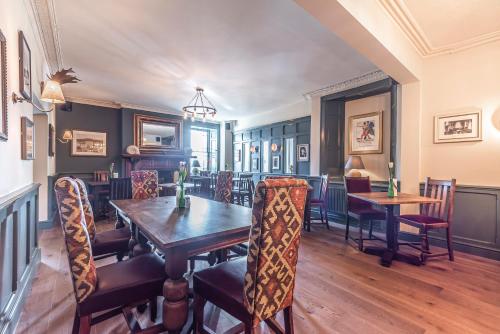 a dining room with a wooden table and chairs at Cockhaven Arms in Bishopsteignton