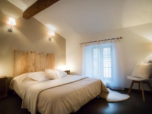 une chambre avec un grand lit et une fenêtre dans l'établissement Les clés de la Cité - 5 appartements, à Carcassonne