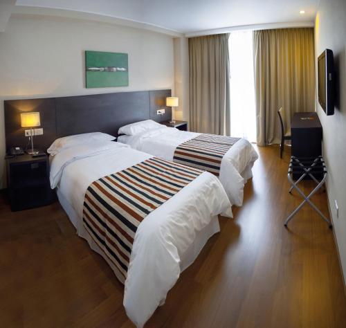 a hotel room with two beds and a television at Amérian Rosario in Rosario