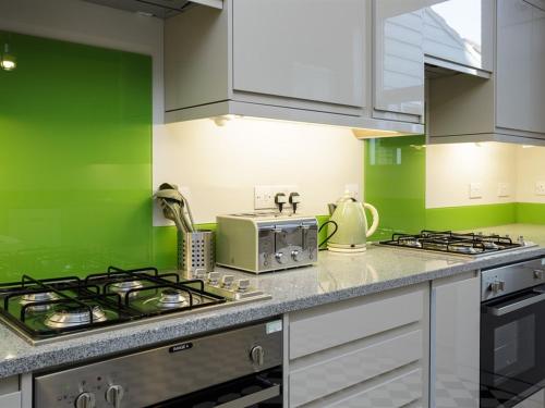 a green kitchen with a stove and a microwave at Blue Star House in Portsmouth