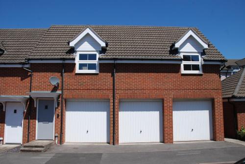 um edifício de tijolos vermelhos com quatro portas de garagem em Coach House em Southampton
