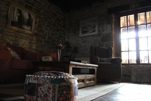 a living room with a couch and a table and a window at Posada Condado de la Mota in Mogro