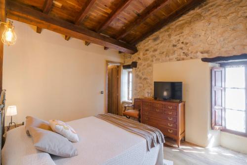 a bedroom with a bed and a television in a room at Posada Condado de la Mota in Mogro