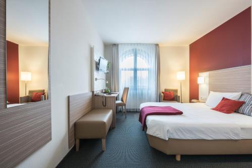 ein Hotelzimmer mit einem Bett und einem Schreibtisch in der Unterkunft Hotel Monika in Büttelborn