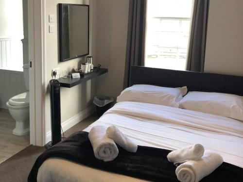 a bedroom with a bed with towels on it at The Cornubia Inn in Hayle