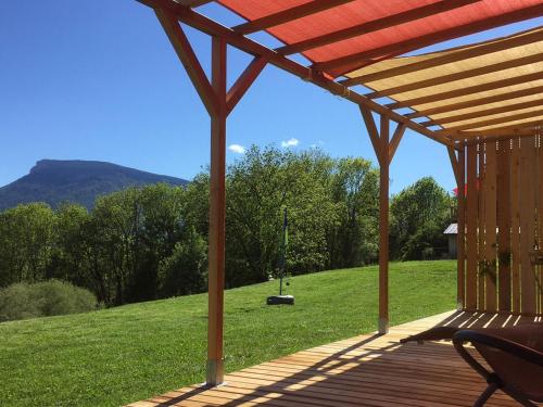 a wooden deck with a gazebo in a field at Gite Basse Correo in La Freissinouse