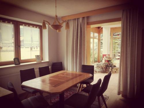 a dining room with a wooden table and chairs at Ferienhof Kampfl in Fügen