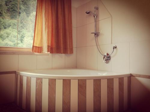 a bath tub in a bathroom with a window at Ferienhof Kampfl in Fügen