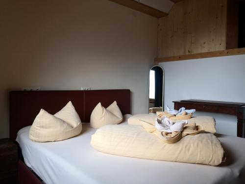 a bedroom with two beds with white sheets and pillows at Ferienhof Kampfl in Fügen