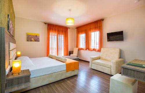 a bedroom with a bed and a couch and a chair at Garden in Limenaria