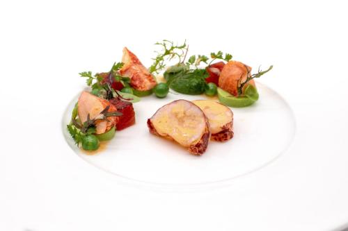 a white plate of food with vegetables and meat at Gourmet Hotel Zur Post in Saint-Vith