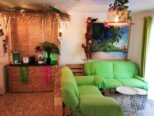 a living room with a green couch and a chandelier at Wonder Rooms Nerja Guest House in Nerja