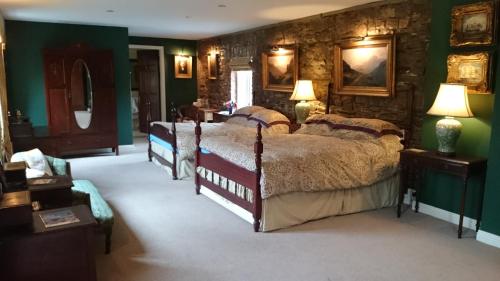 a bedroom with three beds and a stone wall at Kilmokea Country Manor & Gardens in New Ross