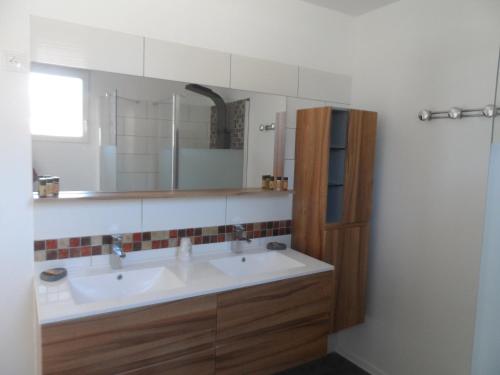 a bathroom with a sink and a mirror at Cottage Cafecouet'Breizh in Guipry-Messac