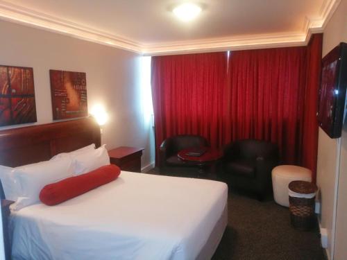 a hotel room with a bed and a red curtain at La Mercy Beach Hotel in La Mercy