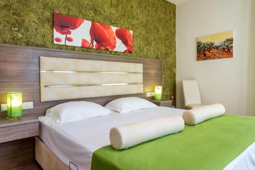 a bedroom with a large white bed with a green table at Garden in Limenaria