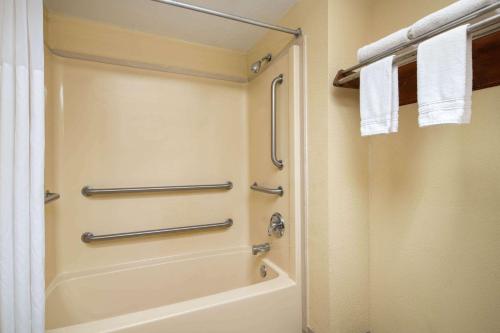 uma casa de banho com uma banheira e um chuveiro com toalhas em Days Inn by Wyndham Thomaston em Thomaston