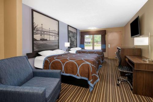 a hotel room with two beds and a desk at Super 8 by Wyndham Gadsden AL in Gadsden