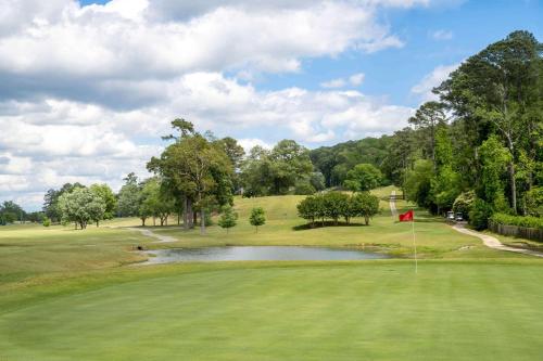 a view of a golf course with a pond at Super 8 by Wyndham Gadsden AL in Gadsden